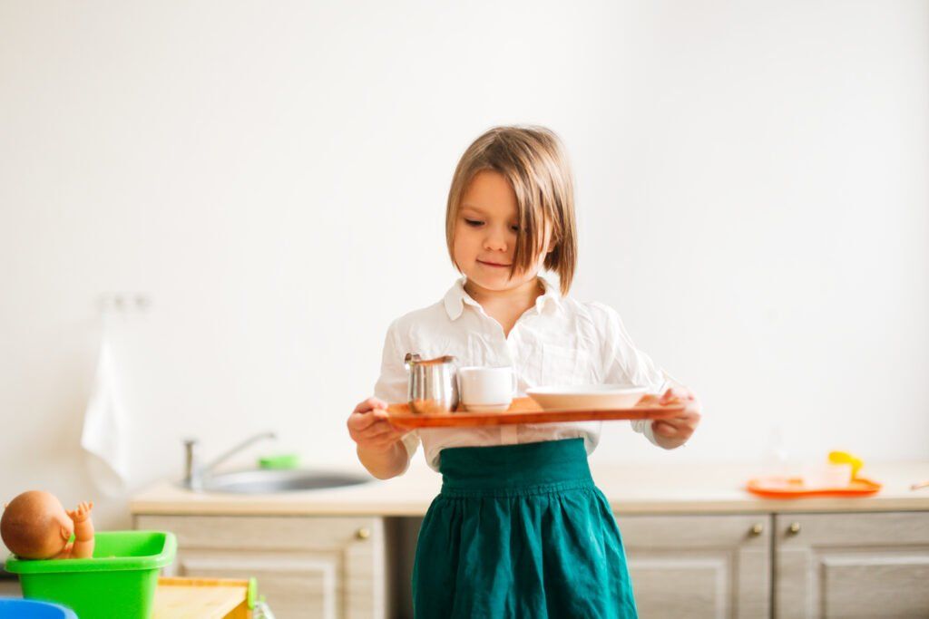 imagen de un niño que lleva una bandeja en Montessori.