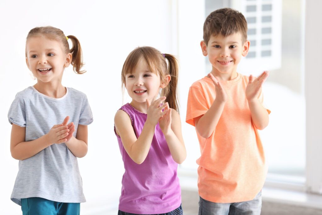 imagen de 3 niños aplaudiendo a las canciones de la letra b.